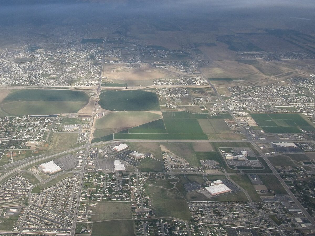 Aerial view of Riverton and Herriman, Utah: subdivisions, farm fields and shopping centers on the valley floor